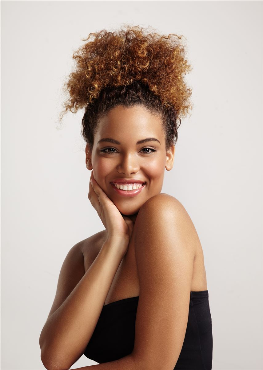 Mulher sorrindo após cuidados estéticos faciais